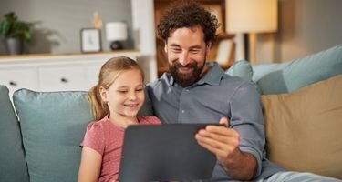 Mann mit Kind die auf einen Computer schauen